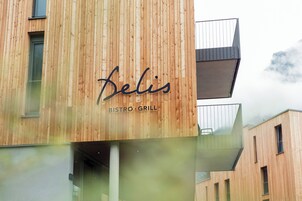 Fachada de madera de un edificio con el nombre 'Belis' y 'BISTRO GRILL', indicando un restaurante.