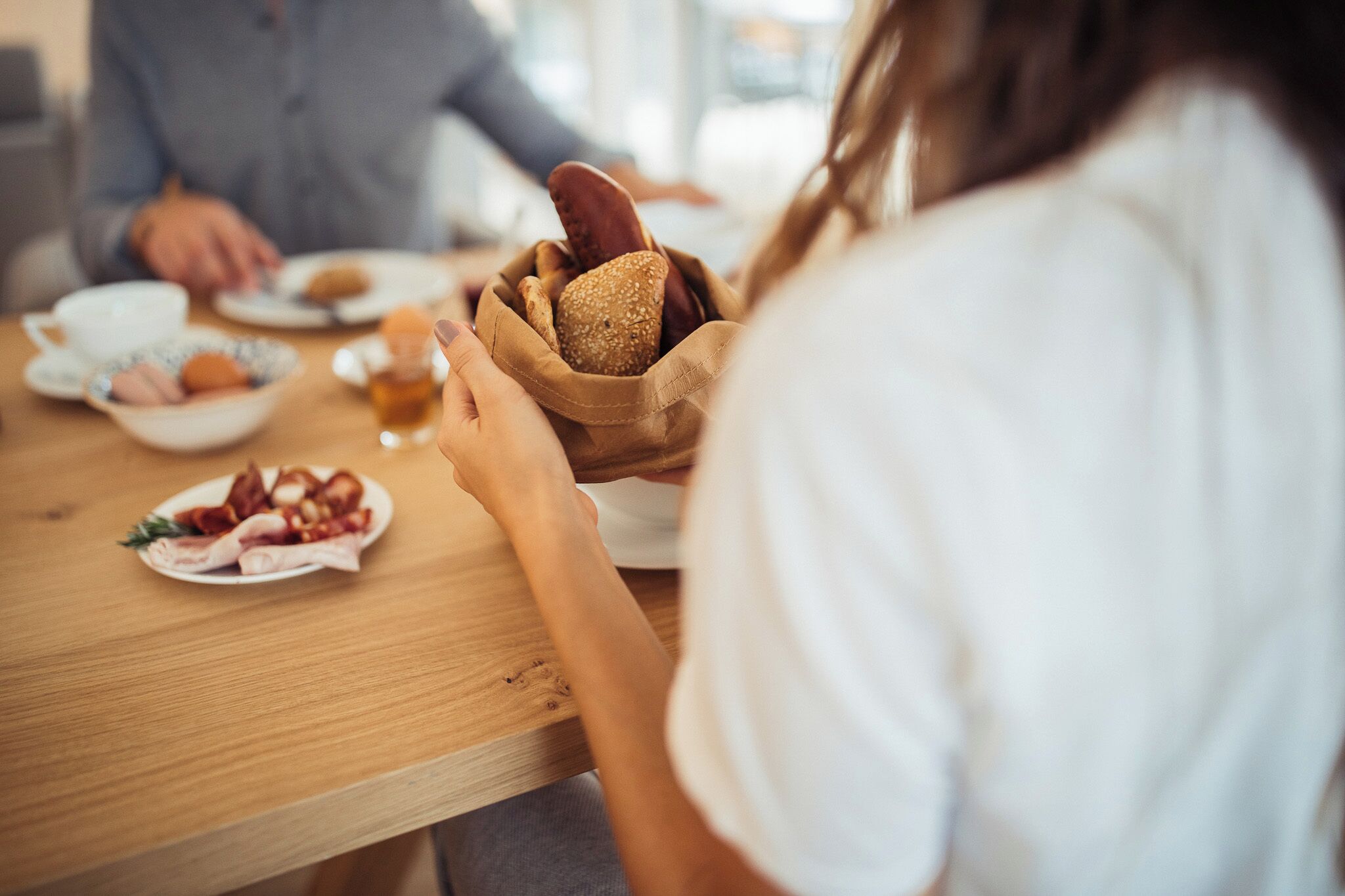 Een eettafel met een broodkom en een bord eten.