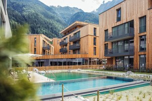 Un edificio moderno con piscina y vistas a la montaña.