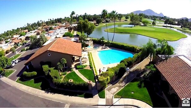 Un quartier résidentiel doté d’une piscine, d’un terrain de golf et offrant une vue sur une montagne en arrière-plan.