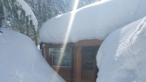 A snow-covered path leading to a wooden building with a sign reading "Barnard."