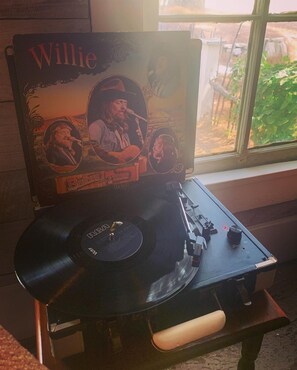 Enjoy music in the comfort of your room with a vintage turntable and a vinyl record at your fingertips.