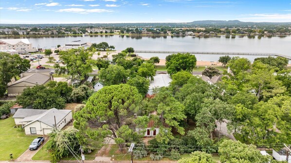 A residential area with houses, a large body of water, and a bridge. - Historic 1890s Cottage: Walk to historic square, beach, & hiking trail! (Granbury)