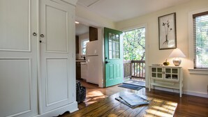 Una cocina espaciosa con puerta verde, piso de madera y vistas al exterior.