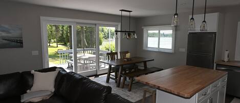 A modern kitchen with a wooden island, stainless steel refrigerator, and pendant lighting.