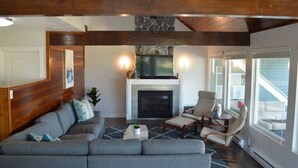 A living room with a fireplace, a sofa, a coffee table, and a chair.