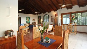 Un'ampia sala da pranzo con tavolo in legno, sedie e ventilatore a soffitto.