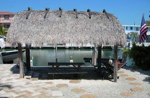 Relax by the water at this serene pavilion, featuring a bench and table for dining or unwinding.