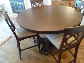 Enjoy meals around a round dining table with four comfortable chairs.