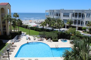 A pool area with lounge chairs, a small pool, and a view of the beach and ocean. - King and Prince Oceanfront Beach Villa (Saint Simons Island)