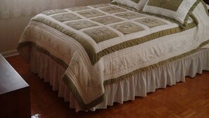 A bedroom with a bed, a window with sheer curtains, and a framed picture on the wall. - Green Valley Cottage (Leicester)