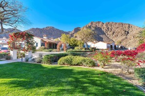 A residential area with houses, a well-maintained lawn, and a mountain backdrop.