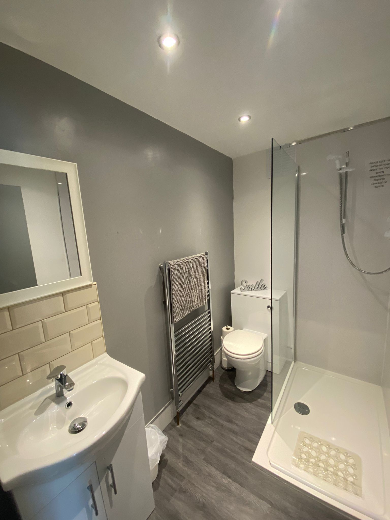 A modern bathroom with a sink, toilet, and shower.