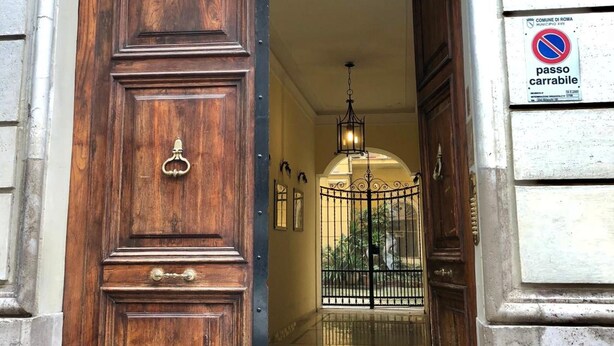 A wooden door with a brass handle, a metal gate, and a sign indicating a no parking zone. - Gracchi Guest House (Rome)