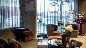 Una sala de estar moderna con sofá, sillones, una mesita de centro y objetos decorativos.