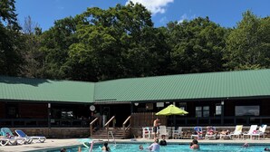 A swimming pool with lounge chairs and a building in the background. - Nanny’s River Cabin_Peaceful Blue Ridge Mountain Retreat in Linville Land Harbor (Newland)
