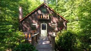 A rustic cabin with a wooden exterior, a front porch, and a chimney. - Nanny’s River Cabin_Peaceful Blue Ridge Mountain Retreat in Linville Land Harbor (Newland)
