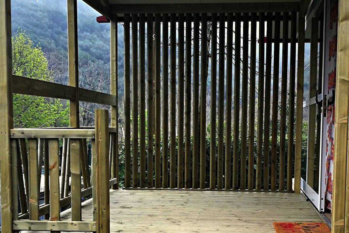 Una terraza de madera con vista a un paisaje montañoso.