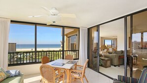 A balcony with a dining table and chairs, a sofa, and a view of the beach. - Gulf & Bay Club, TopFloor End Unit 1947sqft incl Lanai, (Siesta Key)