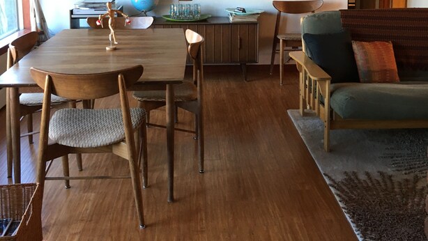 A cozy living room with a wooden dining table, chairs, a sofa, and a globe on the table. - Authentic Mid-Century Marvel, in the quiet and desirable Mid Town neighborhood. (Bend)