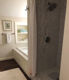Bathtub, hair dryer, towels, toilet paper