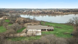 A house with a large yard and a lake in the background. - Beautiful Kayewood Waterfront Retreat (Little Elm)