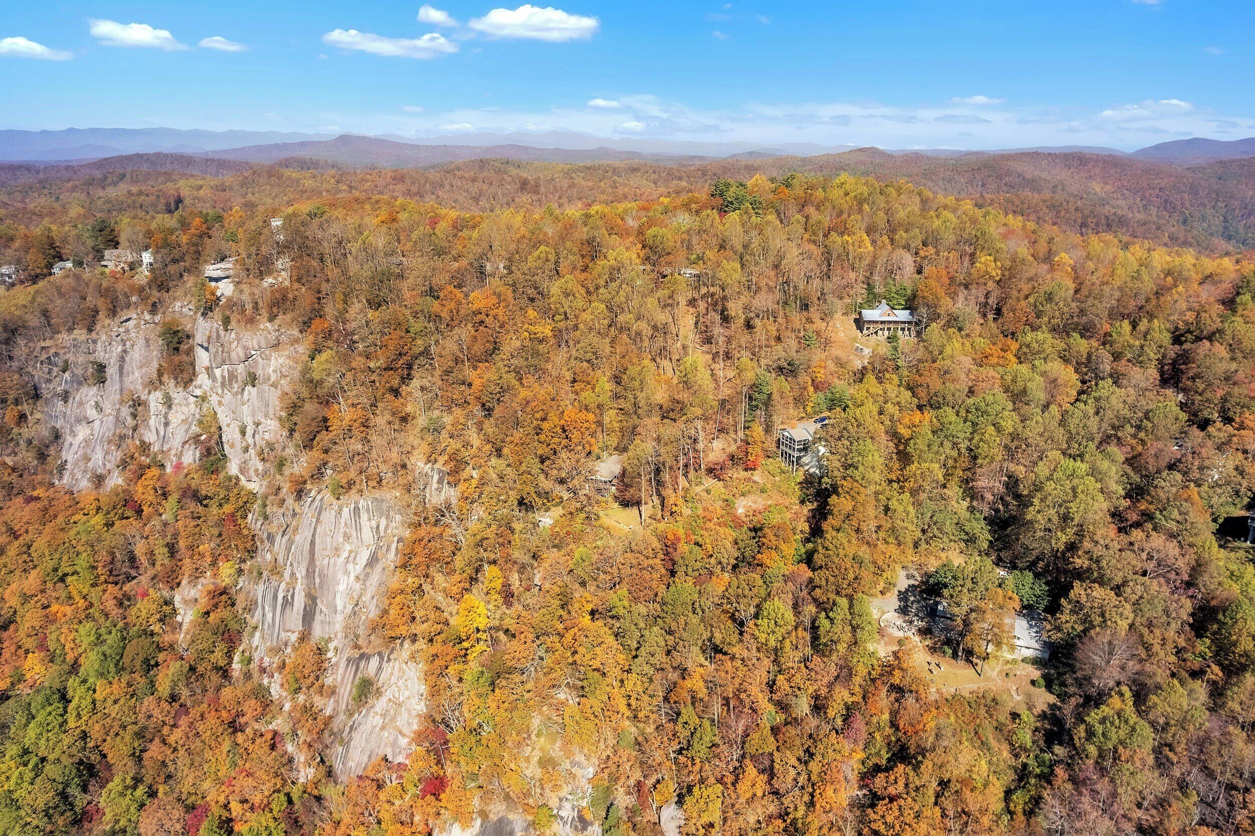 A mountainous landscape with autumn foliage and scattered buildings.