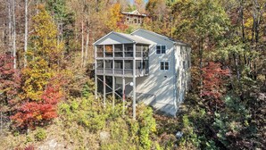 A two-story cabin with a balcony, surrounded by autumn foliage. - Caesar's Head Mountain Home ~ Sleeps 13 ~ Table Rock & Blue Ridge Views (Cleveland)