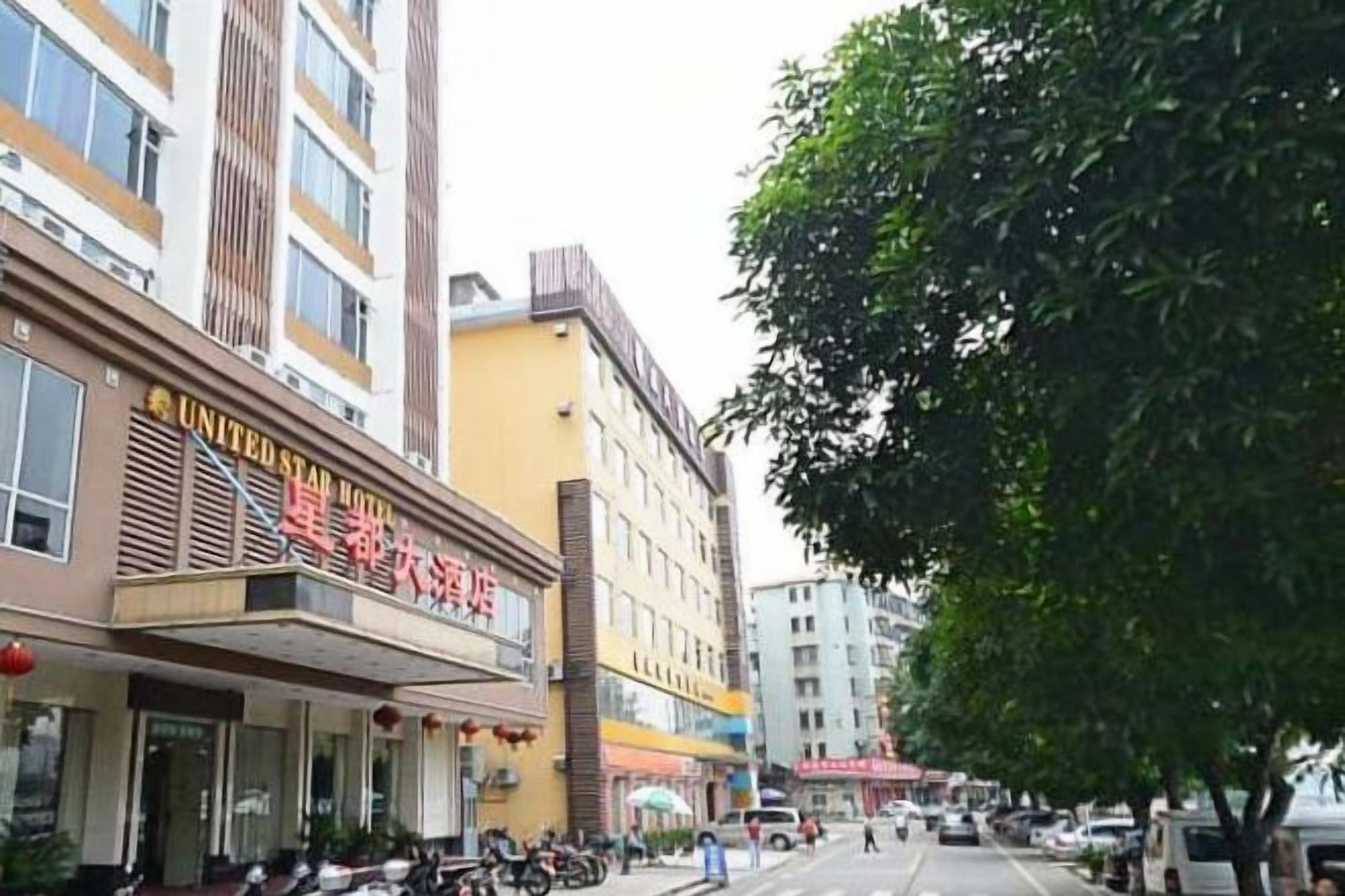 A hotel with a visible entrance, a parking area, and a street view.