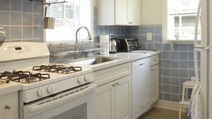 A modern kitchen with white appliances, a stainless steel range hood, and a window with blinds. - Brand New Cottage In Great Berkeley Neighborhood.  (Berkeley)