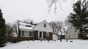 A two-story house with a snow-covered front yard and a brick exterior. - JUST REMODELED top to bottom -  master bed/bath on main floor! (Cleveland Heights)
