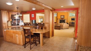 Une cuisine spacieuse dotée de meubles en bois, d’un plan de travail en granit et d’un coin repas avec une table et des chaises.