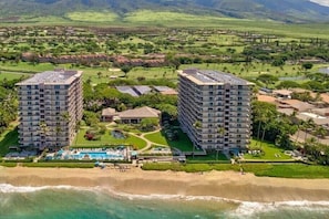 A resort with two high-rise buildings, a pool, and a beach.