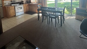 Eine geräumige Küche mit Holzschränken und einem Essbereich mit Tisch und Stühlen.
