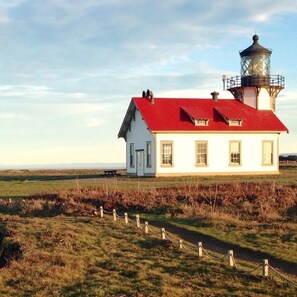 A lighthouse with a red roof and a white building beside it. - Kona Cabin in the Redwoods (Fort Bragg)