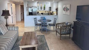 Ein modernes Wohnzimmer mit einer Couch, einem Couchtisch und einem Essbereich mit Stühlen und einem Tisch.