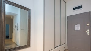 A room with a large mirror, a wardrobe, a door with a lock, and a small vent above the door. - ShortStayPoland Środkowa - B49 (Warsaw)