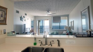 A kitchen with a modern design, a large window, and a view of the outdoors.