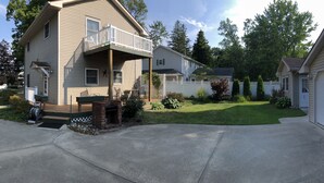 A two-story house with a covered porch, a garage, and a well-maintained lawn.