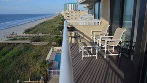 A balcony with a pool, beach view, and outdoor seating. - Shoreham Towers II -  Corner Unit - Wrap-around Ocean Views (North Myrtle Beach)