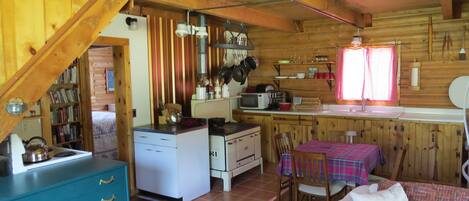 A cozy cabin interior with a kitchen, dining area, and a living room.