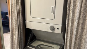 A compact, white, wall-mounted washer and dryer unit with a control panel and a small window. - Cozy Cabin Minutes from Glacier's Two Medicine Valley (East Glacier)