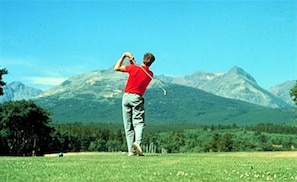 Golfers can enjoy a serene mountainous landscape with lush greenery.