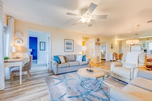 Relax in this inviting living area with a comfortable sofa, armchair, and coffee table, surrounded by artwork and decorative pieces.