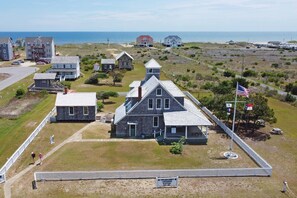 Stunning historic lifesaving station with a gabled roof and central tower, set amidst a charming coastal community.