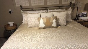 A neatly made bed with patterned bedding and a decorative throw pillow. - Tranquil East Wing Suite Redlands Grand Junction, Colorado (Grand Junction)