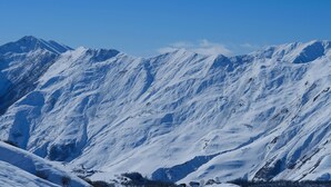 A snow-covered mountain range with clear skies. - GUDASKI Apartments (Kazbegi)