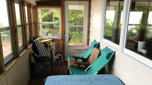 A small, cozy room with a bed, a chair, and a window. - Access to the best white sand beach in the Keweenaw! (Gay)