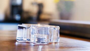 A blurred indoor setting with a wooden table and a glass object.