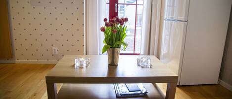 Una mesa de madera con un florero y dos vasos encima.